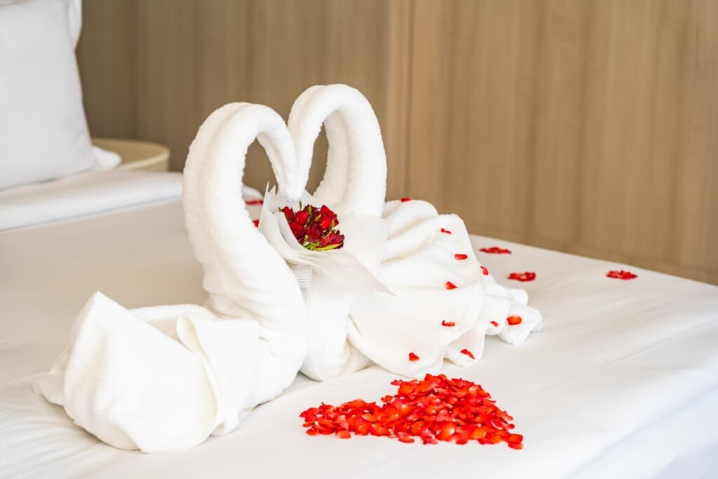 Swan towel on bed with red rose flower decoration interior